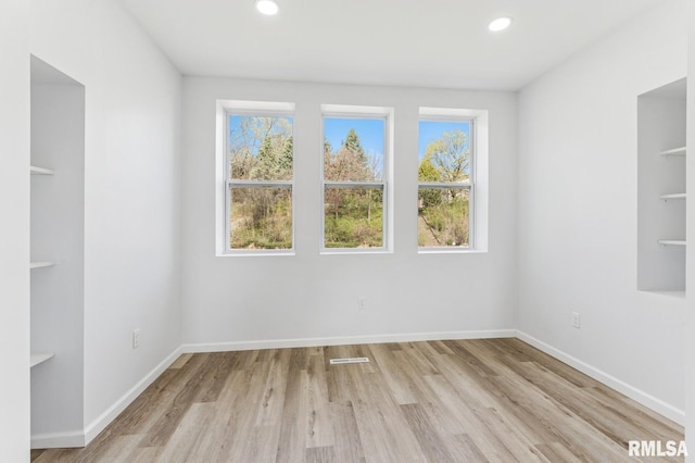 unfurnished room featuring recessed lighting, plenty of natural light, and light wood-style flooring