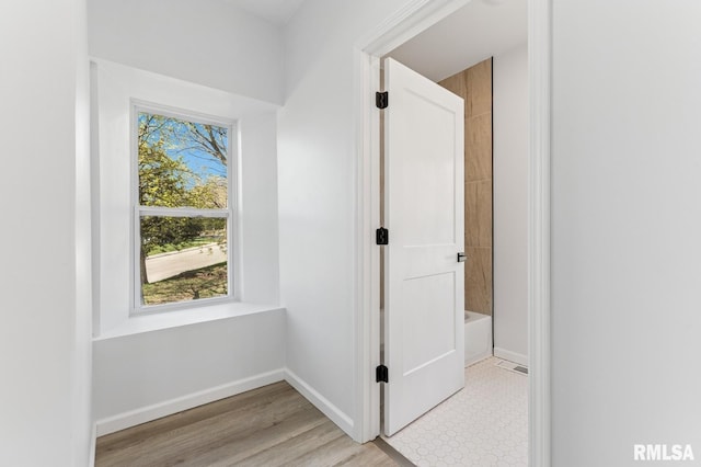 hallway with light wood finished floors and baseboards