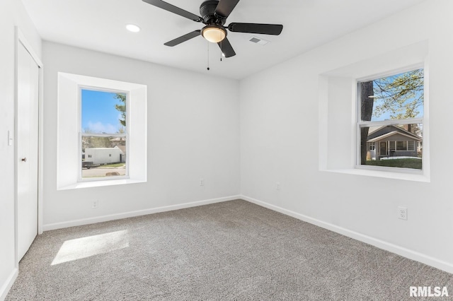 empty room featuring carpet, a ceiling fan, visible vents, recessed lighting, and baseboards
