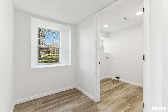 clothes washing area featuring a wealth of natural light, hookup for an electric dryer, visible vents, and light wood-style flooring