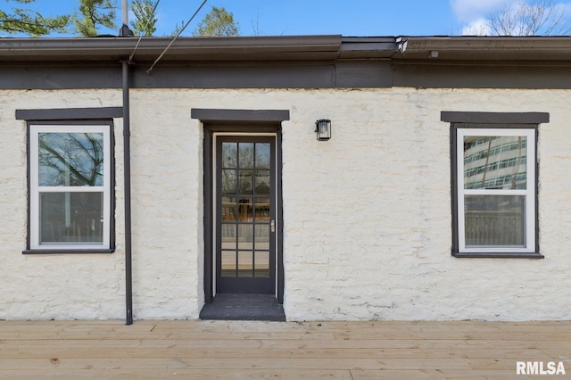 view of exterior entry with a wooden deck