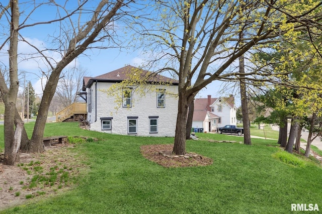 view of home's exterior featuring a yard and stairway