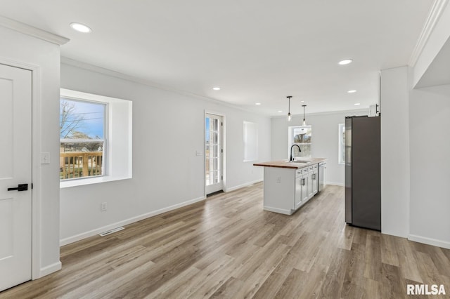 kitchen with a sink, a wealth of natural light, visible vents, and stainless steel appliances