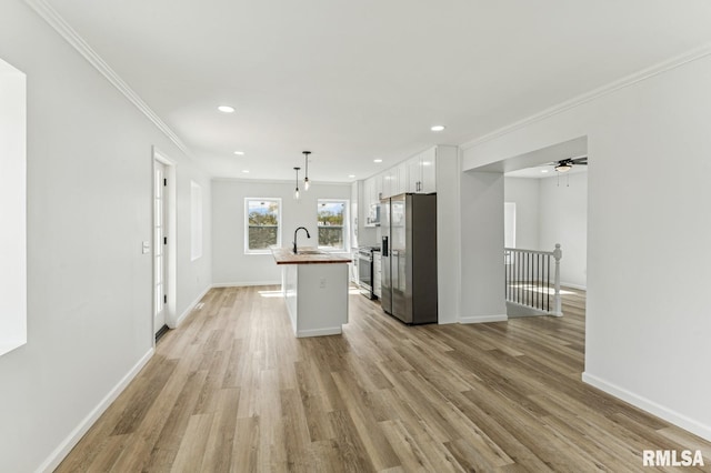 kitchen featuring stainless steel fridge with ice dispenser, a sink, crown molding, white cabinetry, and light wood finished floors