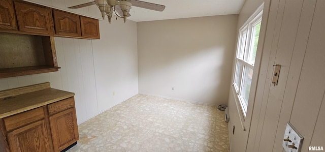 1606 Middle Rd, Camanche, IA 52730 - unfurnished dining area featuring a ceiling fan, light flooring, and baseboards