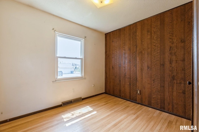 1606 Middle Rd, Camanche, IA 52730 - empty room featuring light wood-type flooring, baseboards, and wooden walls