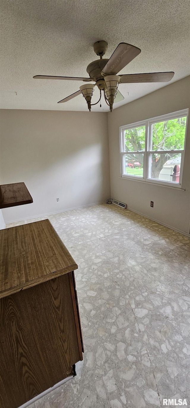 1606 Middle Rd, Camanche, IA 52730 - unfurnished living room with ceiling fan, stone finish flooring, and a textured ceiling