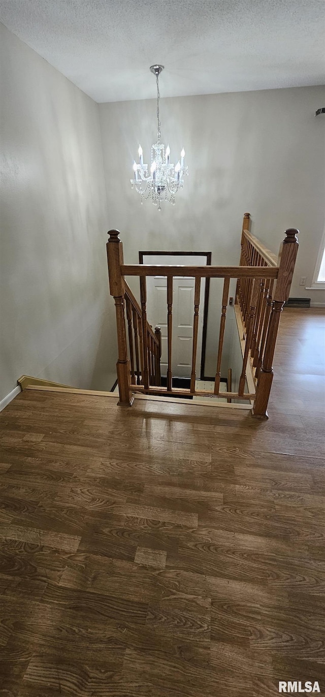 1606 Middle Rd, Camanche, IA 52730 - staircase with a chandelier, wood finished floors, and a textured ceiling