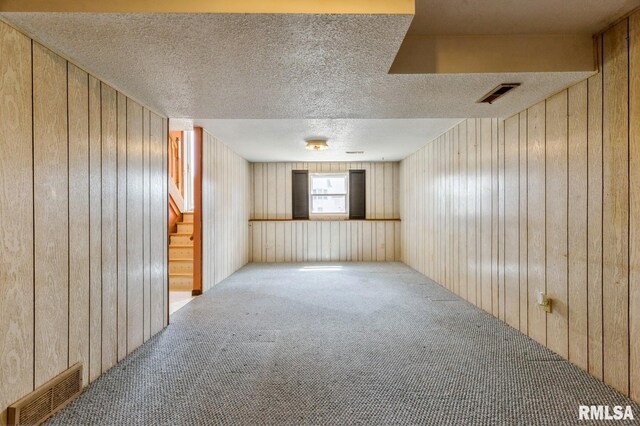 1606 Middle Rd, Camanche, IA 52730 - unfurnished room with carpet floors, wood walls, a textured ceiling, and stairway