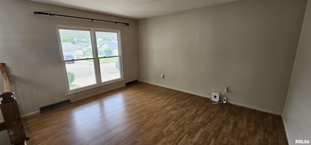 1606 Middle Rd, Camanche, IA 52730 - unfurnished room featuring dark wood-style flooring, baseboards, and a textured ceiling
