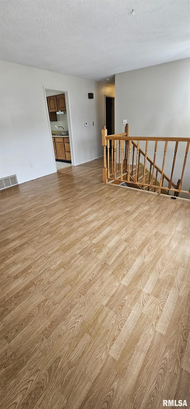 1606 Middle Rd, Camanche, IA 52730 - unfurnished room featuring wood finished floors, a textured ceiling, and a sink