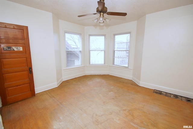705 Brady St, Davenport, IA 52803 - empty room featuring light wood-style flooring, a ceiling fan, and baseboards