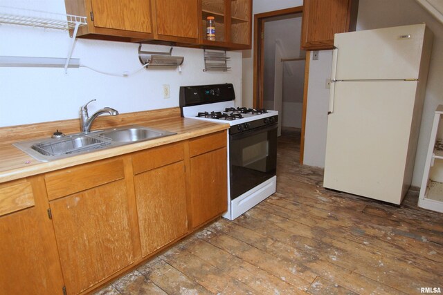 705 Brady St, Davenport, IA 52803 - kitchen featuring light countertops, a sink, wood-type flooring, freestanding refrigerator, and gas range