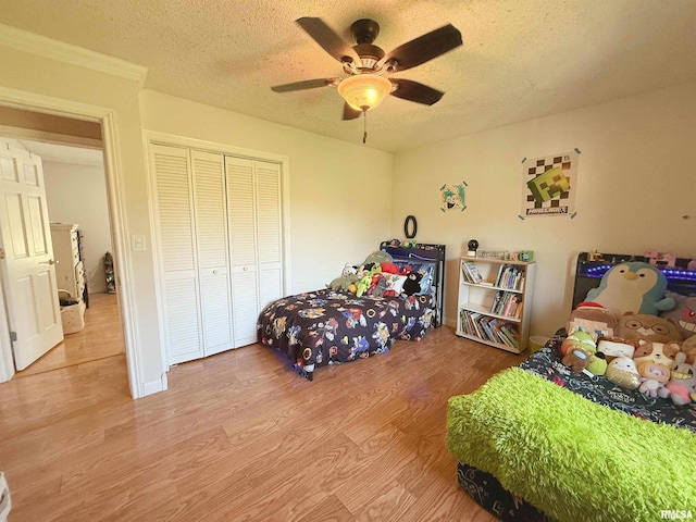 bedroom featuring wood finished floors, a textured ceiling, a closet, and ceiling fan