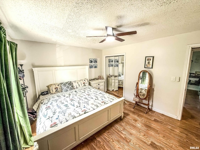 bedroom with a ceiling fan, wood finished floors, a textured ceiling, a closet, and baseboards