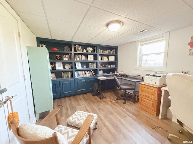 office area featuring light wood-style floors, visible vents, and a drop ceiling