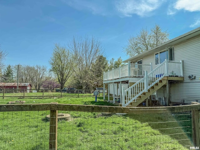 view of yard with a wooden deck, stairway, and fence
