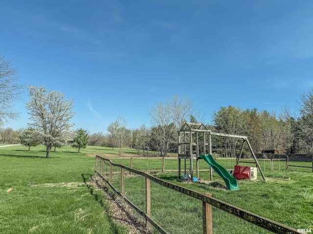 view of playground with a lawn and fence
