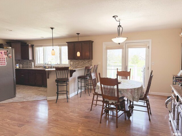 dining area with baseboards and light wood-style floors