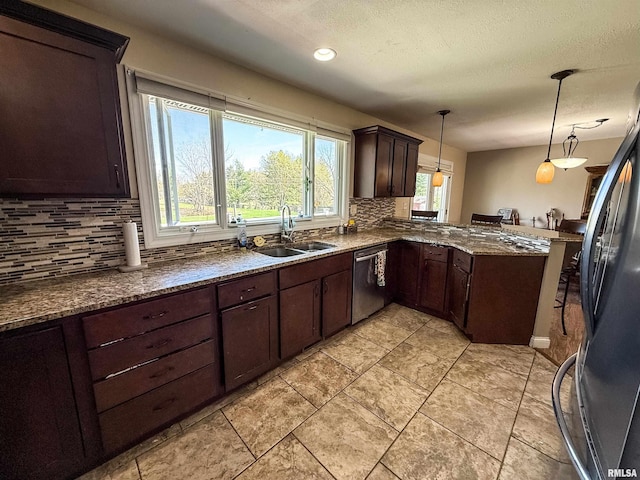 kitchen with a peninsula, a sink, freestanding refrigerator, decorative backsplash, and dishwasher