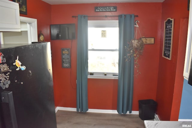 doorway to outside featuring baseboards and wood finished floors