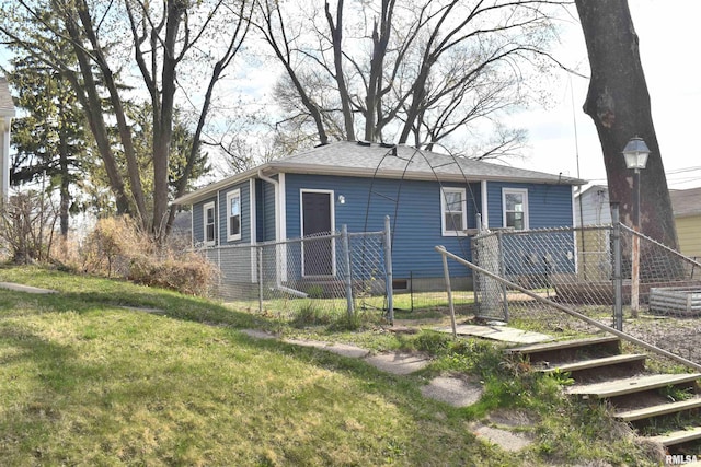 exterior space with a front lawn, fence, and a shingled roof