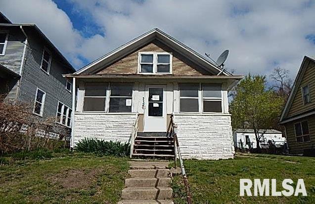 bungalow featuring entry steps and a front lawn
