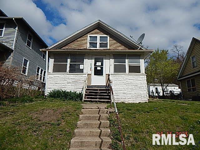 bungalow-style home with entry steps and a front yard