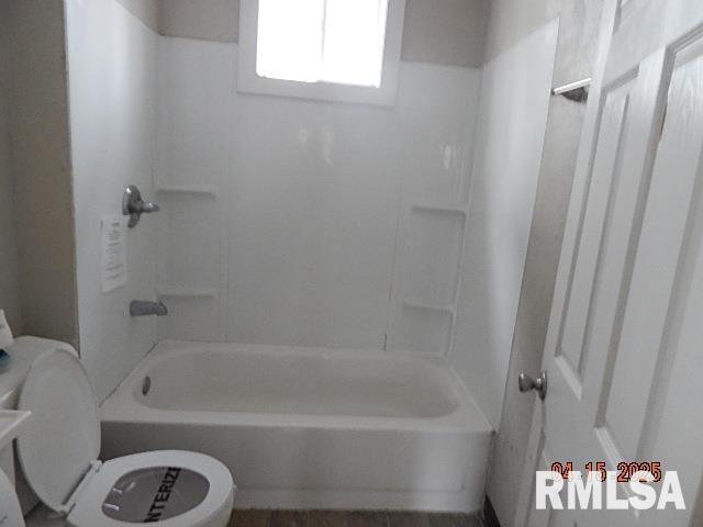 bathroom with washtub / shower combination and toilet