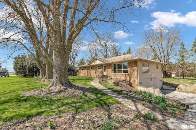 view of home's exterior with brick siding and a lawn