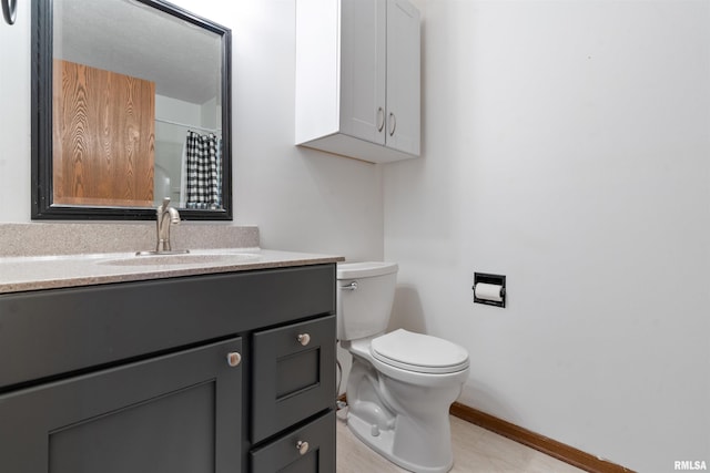 bathroom with baseboards, toilet, vanity, and a shower with curtain