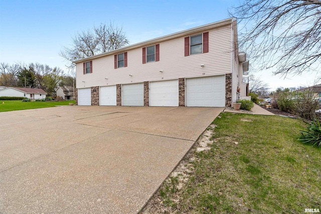 view of front facade featuring an attached garage, driveway, and a front yard