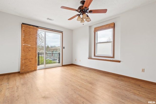 spare room with baseboards, light wood-style flooring, visible vents, and ceiling fan