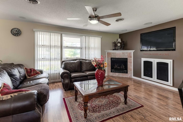 505 W College St, Energy, IL 62933 - living room featuring a ceiling fan, wood finished floors, a textured ceiling, a tile fireplace, and visible vents