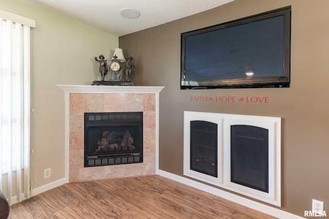 505 W College St, Energy, IL 62933 - unfurnished living room featuring wood finished floors, a tile fireplace, and baseboards