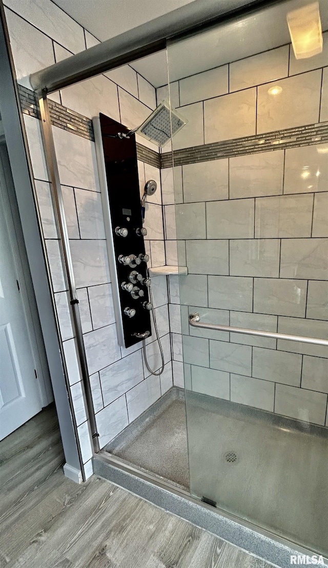 full bath with wood finished floors and a stall shower