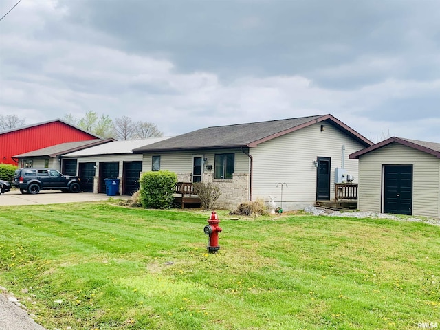 view of front of property with concrete driveway, an attached garage, an outdoor structure, brick siding, and a front yard