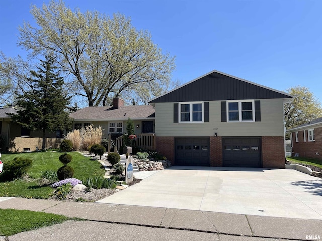 tri-level home with concrete driveway, brick siding, a front lawn, and a garage