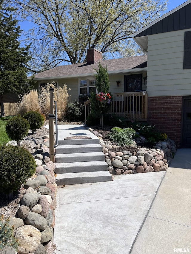 view of front of home with brick siding, a chimney, and a front lawn
