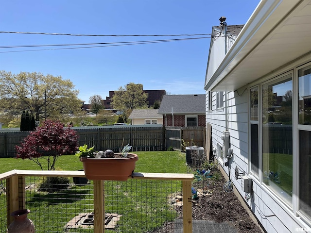 wooden terrace featuring a fenced backyard, a yard, and central AC