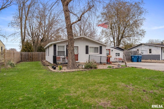 view of front facade featuring a fenced backyard, a wooden deck, and a front yard