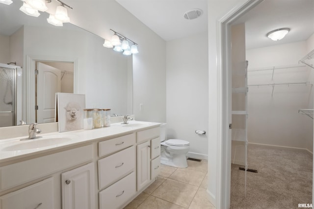 1357 Pinnacle Pines Ct, Bettendorf, IA 52722 - full bathroom featuring double vanity, a walk in closet, toilet, a shower stall, and tile patterned flooring