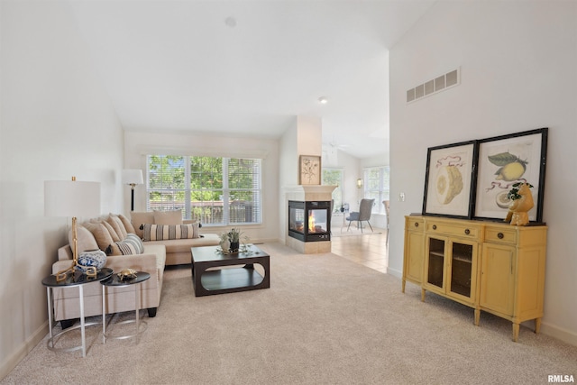1357 Pinnacle Pines Ct, Bettendorf, IA 52722 - living area featuring a multi sided fireplace, light colored carpet, baseboards, and high vaulted ceiling