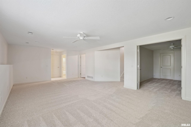 1357 Pinnacle Pines Ct, Bettendorf, IA 52722 - empty room featuring ceiling fan, light carpet, baseboards, and a textured ceiling