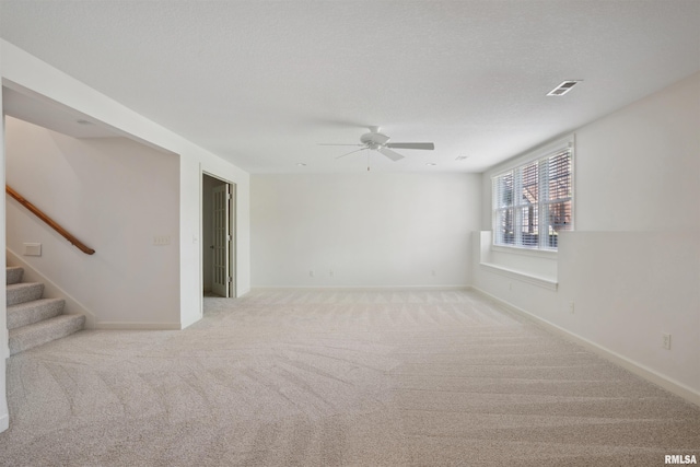 1357 Pinnacle Pines Ct, Bettendorf, IA 52722 - carpeted empty room featuring a ceiling fan, stairs, and baseboards