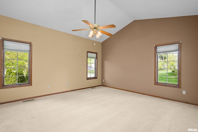 empty room with a ceiling fan, light colored carpet, vaulted ceiling, and visible vents