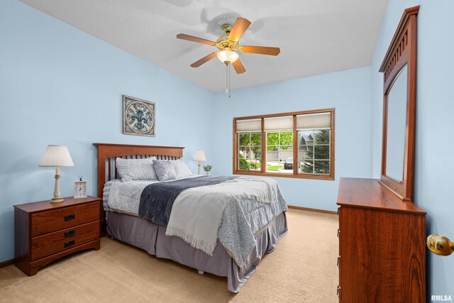 bedroom with ceiling fan, light colored carpet, baseboards, and a closet