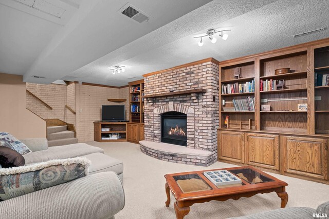living area featuring a textured ceiling, visible vents, a brick fireplace, carpet flooring, and stairs