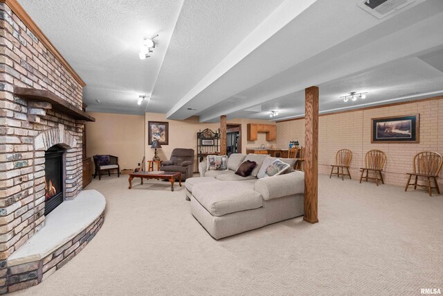 living room with a textured ceiling, light carpet, and a fireplace