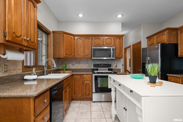 kitchen featuring a kitchen island, appliances with stainless steel finishes, brown cabinetry, and a sink